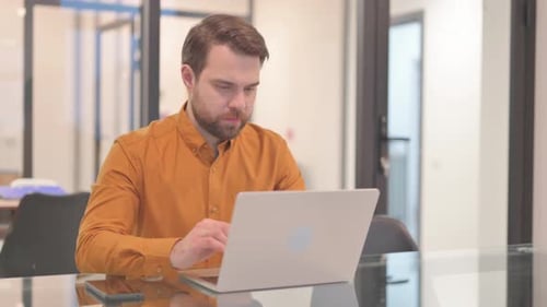 Businessman Shocked by Loss on Laptop in Office