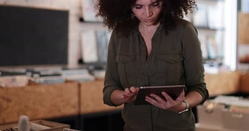 Portrait of small business owner using digital tablet in a record store