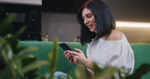 Woman using Smartphone on Couch in Living Room
