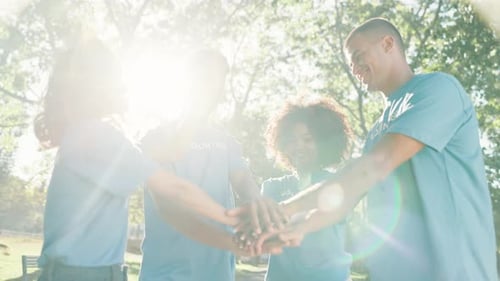Team of Volunteers Putting Hands Together in Park