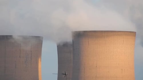 Industrial cooling tower power station chimneys smoking steam pollution, close up smoke blowing left
