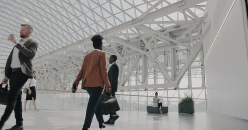 Group of Businessmen and Businesswomen with Bags Walking in Airport Commuting