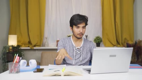 Young Adult Using Laptop For Video Conferencing at Home