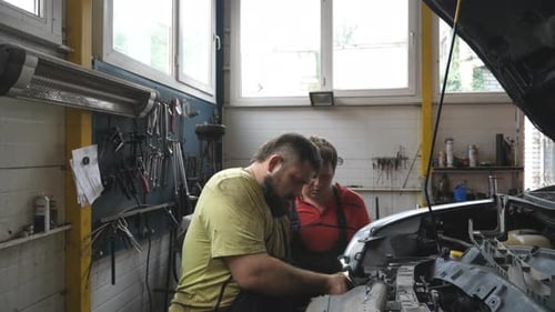 Two Repairmans Fixing Car at Workshop or Service Mechanics Works with Vehicle at Garage Workers