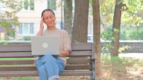 Woman Working on Laptop in City Park