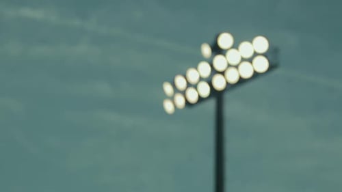 Rack focus of stadium lights during dusk