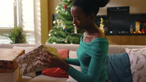 Woman Arranges Christmas Presents in Cozy Home Setting