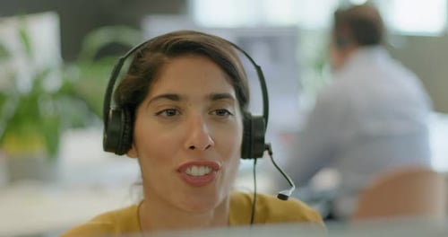 Mujer de negocios con auriculares en una videollamada en una oficina, telemarketing, centro de llamadas