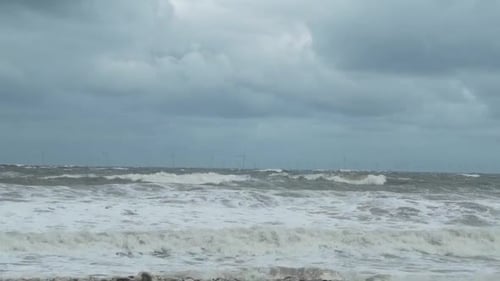 Powerful stormy splashing coastal ocean waves foam blowing in rough windy weather
