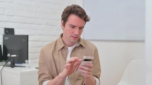 Man Smiles Using Cell Phone Indoors