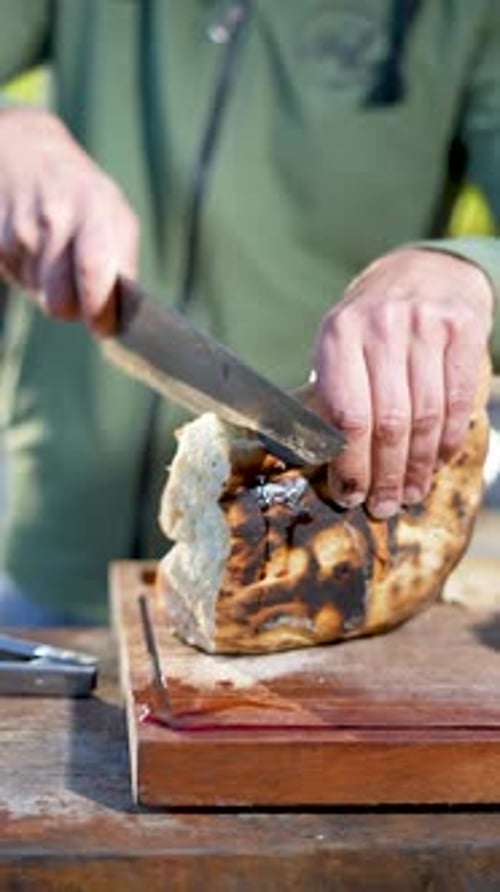 Slicing a loaf of homemade bread with a large sharp knife