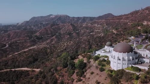 LA: Drone shot over Griffith Observatory looking towards the Hollywood Sign in the distance (paralla