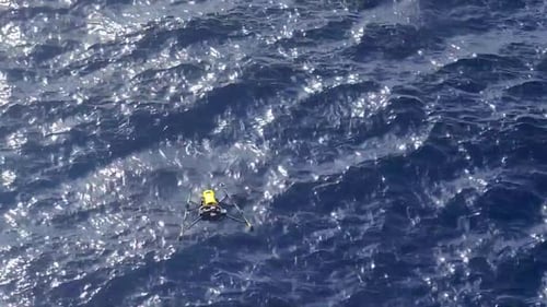 Drone inspecting an offshore oil rig at sea