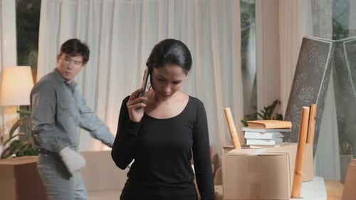 Woman on Phone Directing Movers in House