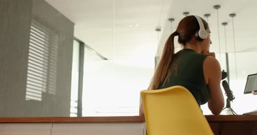 Woman With Headphones Working at Desk