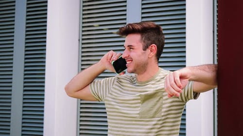 Smiling Man Talking on Cell Phone in Urban Setting