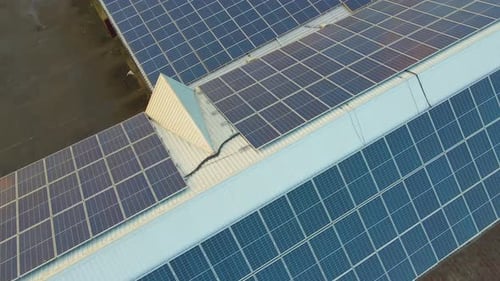 Blue Photovoltaic Solar Panels Mounted on Building Roof for Producing Clean Ecological Electricity