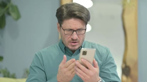 Shocked Middle Aged Man Having Loss on Smartphone