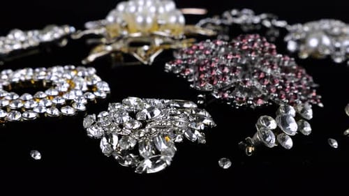 Vintage-Modeschmuck, Broschen mit Kristallen und künstlichen Perlen auf rotierendem schwarzem Samt
