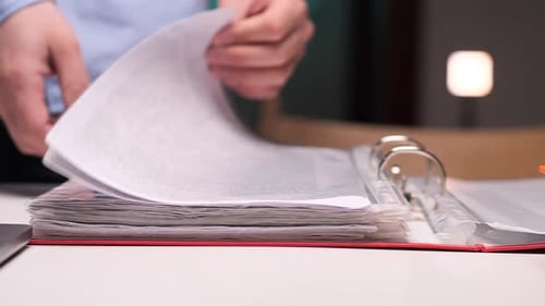Office Worker Browsing Through Documents in a Binder