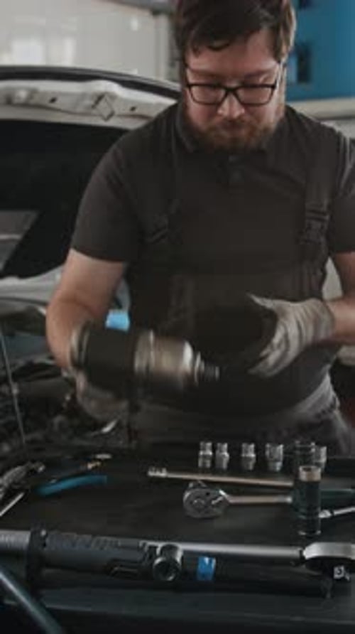 Auto Mechanic Works on Car in the Shop