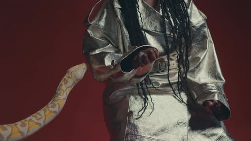 Vue de profil d'un serpent blanc et jaune avec une fille modèle africaine posant en studio.