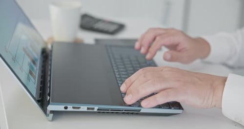 Man in Shirt Typing on Laptop Keyboard in Office and Picking Up Mobile Phone Close Up of Hands