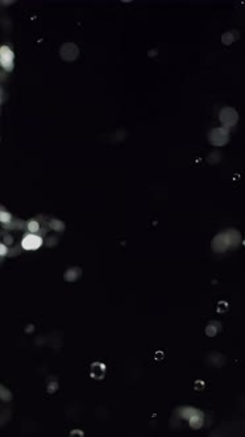 Abstract Water Droplets Falling on Dark Background