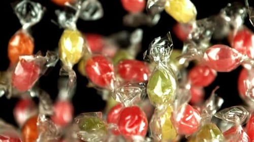 Colorful Wrapped Candies Floating on a Black Background
