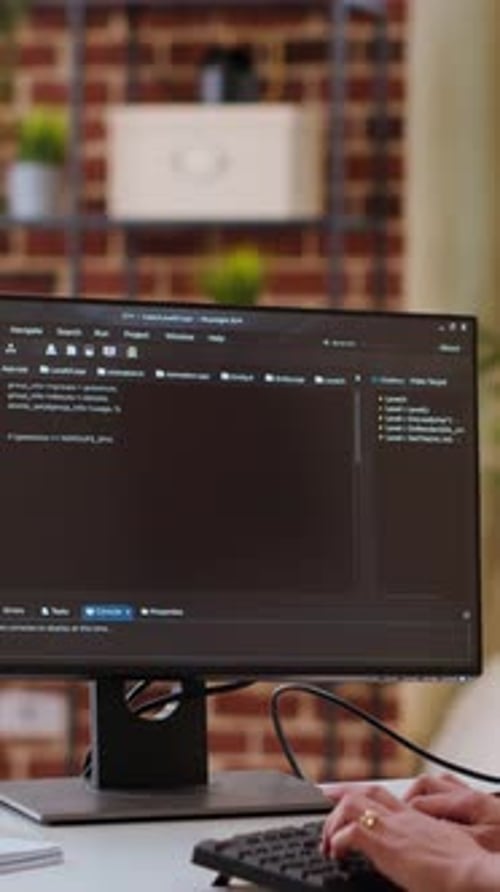 Hands Typing Code on Computer Monitor
