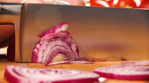 Chef Slicing a Red Onion on Cutting Board