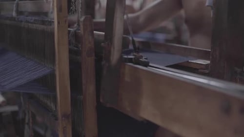 Artisan Weaving Blue Fabric on Traditional Loom