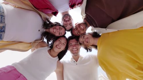 Grupo feliz de jovens em círculo sorrindo para a câmera