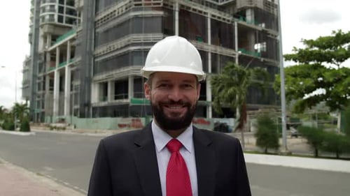 Potrait Senior Engineer Planning Manufacture Work in a Business Suit in a White Protective Helmet