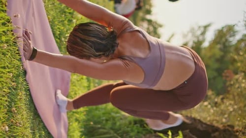 Athletic Group Stretching on a Lawn Outdoors