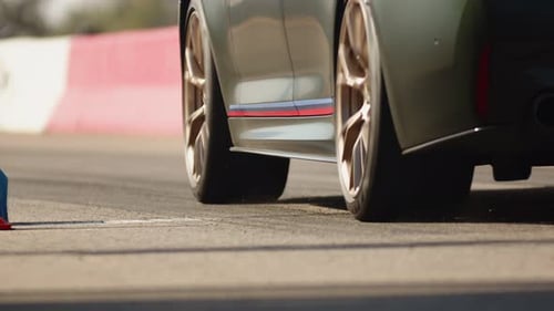 A View From the Bottom to the Rear of a Modern Shiny Sport Car Takes Part in Drag Race on the Track