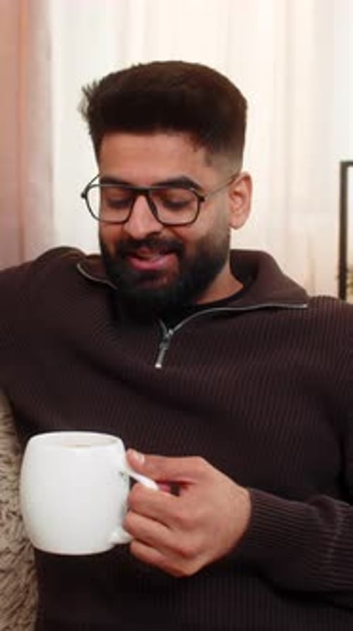 Young Adult Relaxing with a Warm Drink at Home