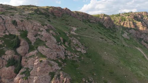 Dunkles Geländefahrzeug fährt auf kurvenreicher Bergstraße