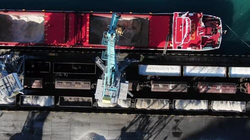 Port Crane Unloads a Large Ship in the Seaport Top Down Aerial View