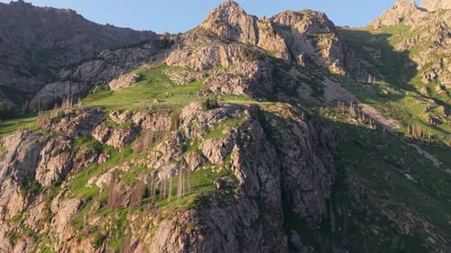 Majestic Mountain Range with Lush Green Vegetation Under Blue Sky