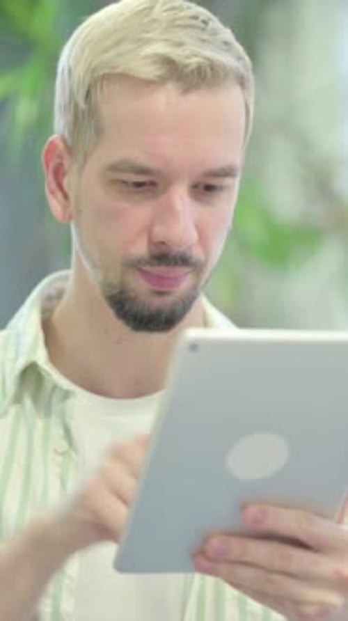 Man Using a Tablet Indoors, Close Up Vertical Footage