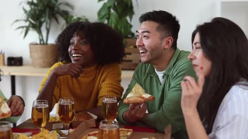Friends Share Pizza and Drinks at Gathering