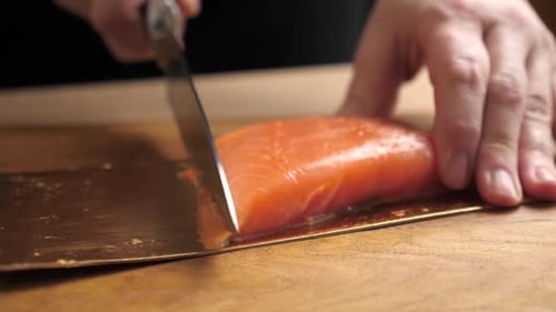 Chef Slicing Salmon Close Up on Cutting Board
