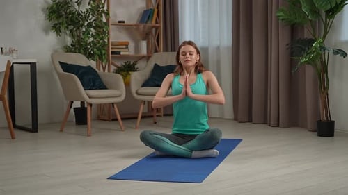 Young Woman Meditating on Yoga Mat at Home