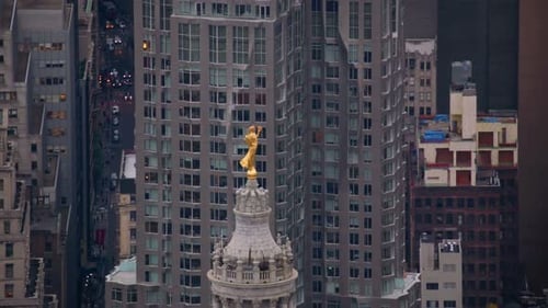Golden statue topping manhattan municipal building in New York City on sunny day