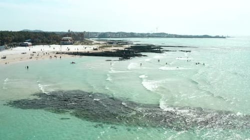 Surfers and waves in the clear blue sea.