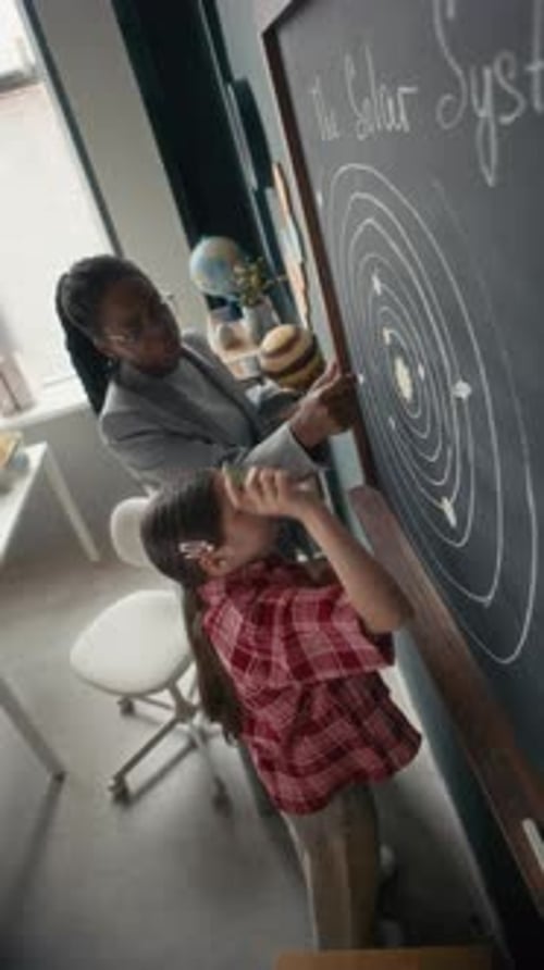 Teacher Helping a Student with Solar System Project