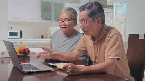 Senior Couple Doing Finances at Kitchen Table