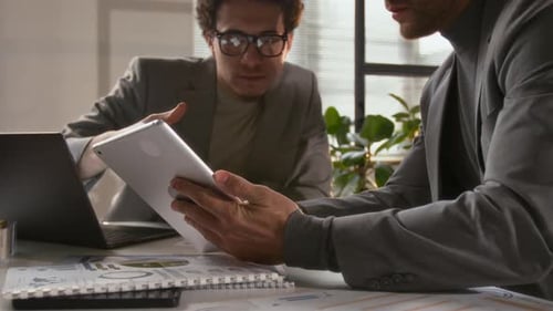 Colleagues Collaborate Using Tablet in Modern Office
