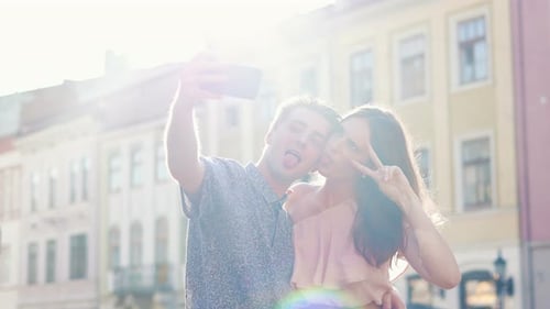 Young Couple in Love Standing on Street and Taking Pictures Selfie Photos People Using Smartphone to